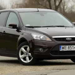Ciemnobrązowy Ford Focus 2 kombi stoi na drodze.
