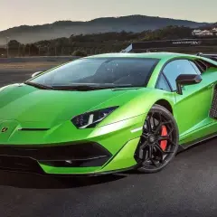 Jaskrawozielony Lamborghini Aventador SVJ na torze wyścigowym, z masywnym skrzydłem i czarnymi felgami.