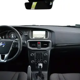 Wnętrze Volvo V40, kierownica, deska rozdzielcza z ekranem nawigacji i panelem sterowania. Wiele osób szuka volvo v40 opinie.