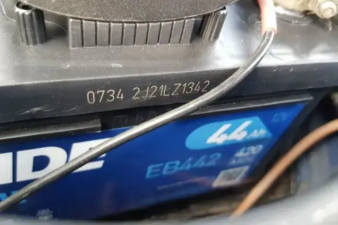 Na akumulatorze widoczny jest numer seryjny 0734 2J21LZ1342, który zawiera **datę produkcji akumulatora**.