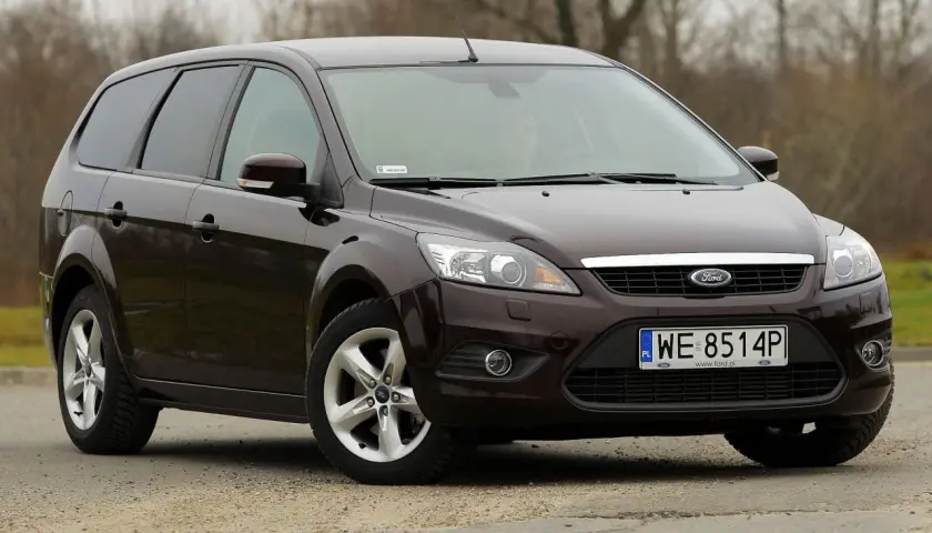 Ciemnobrązowy Ford Focus 2 kombi stoi na drodze.
