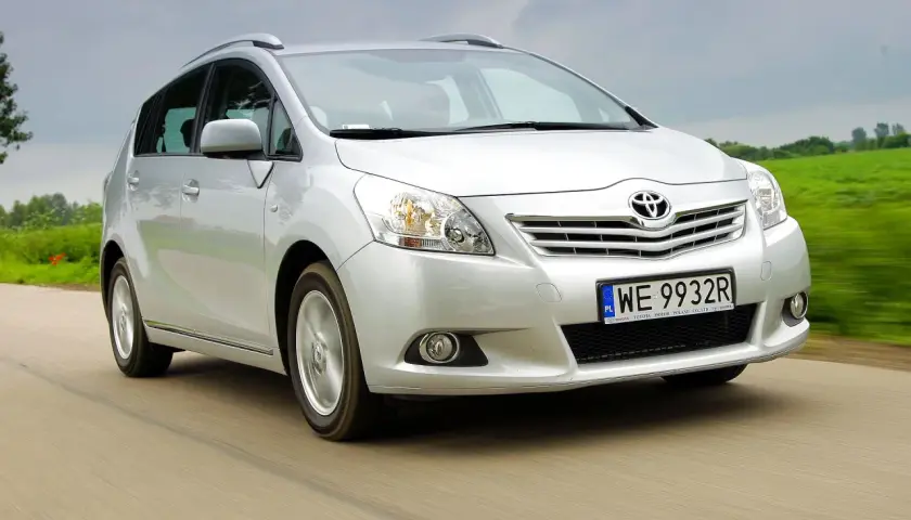 Srebrna Toyota Verso 1.8 benzyna w ruchu, z zielonym polem w tle.