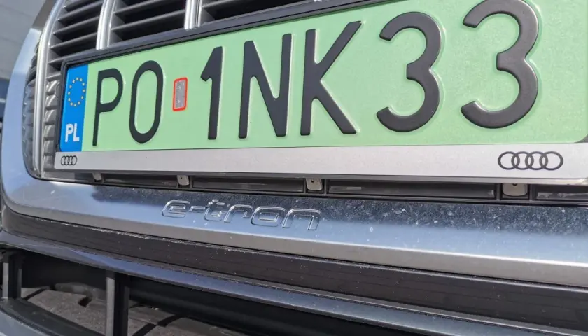 Zielone tablice rejestracyjne z napisem "e-tron" na zderzaku Audi.