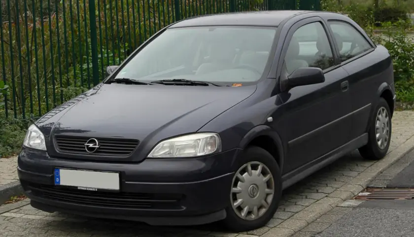 Ciemnoszary Opel Astra G 1.6 16v stoi na chodniku.