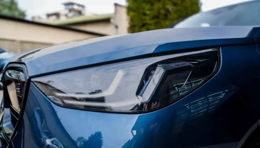 Błyszczący, niebieski lakier BMW z nowoczesnym reflektorem LED. Detailing podkreśla jego sportowy charakter.
