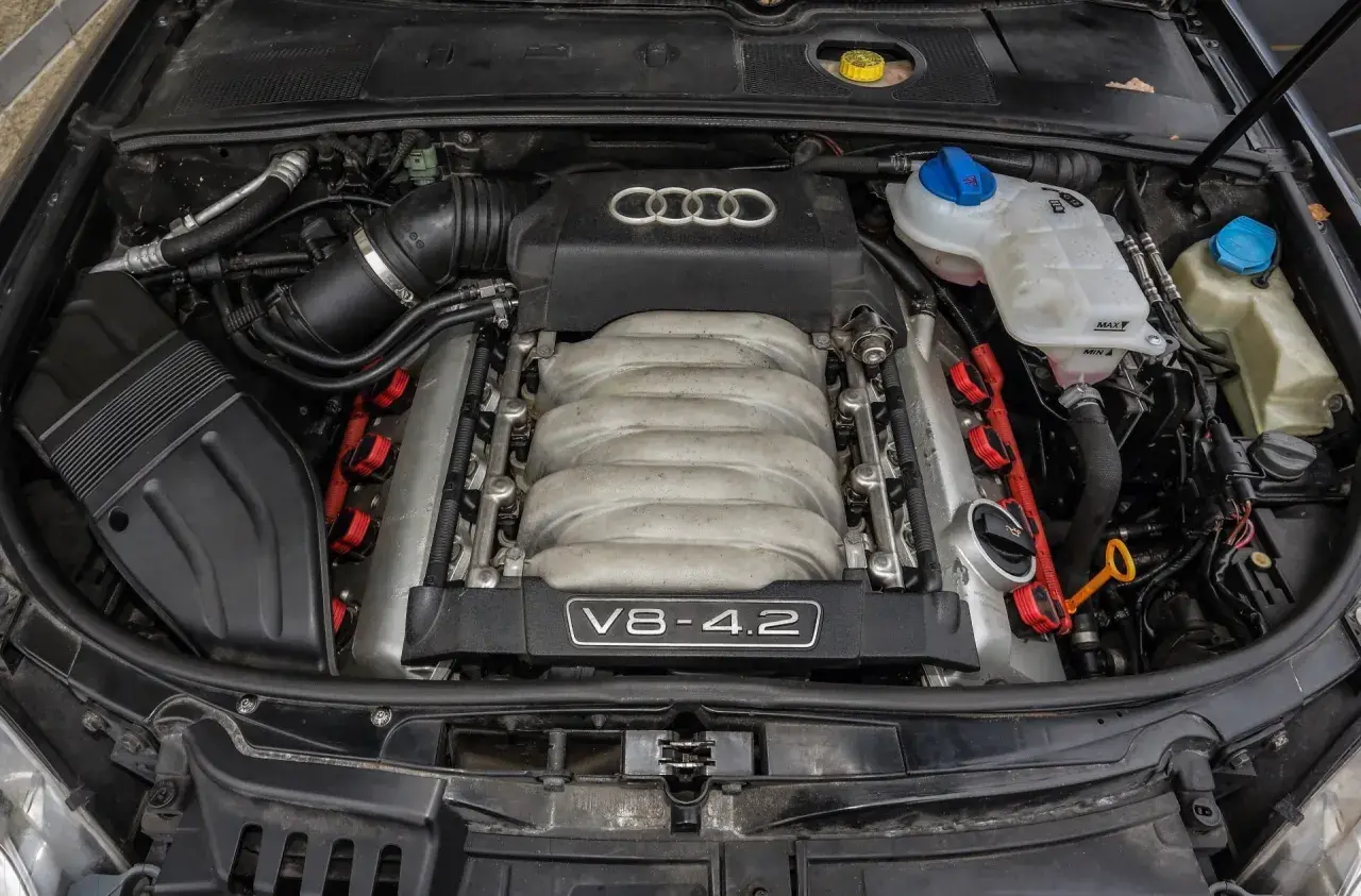 Potężny silnik wolnossący V8 4.2 Audi, z widocznym kolektorem dolotowym i cewkami zapłonowymi.
