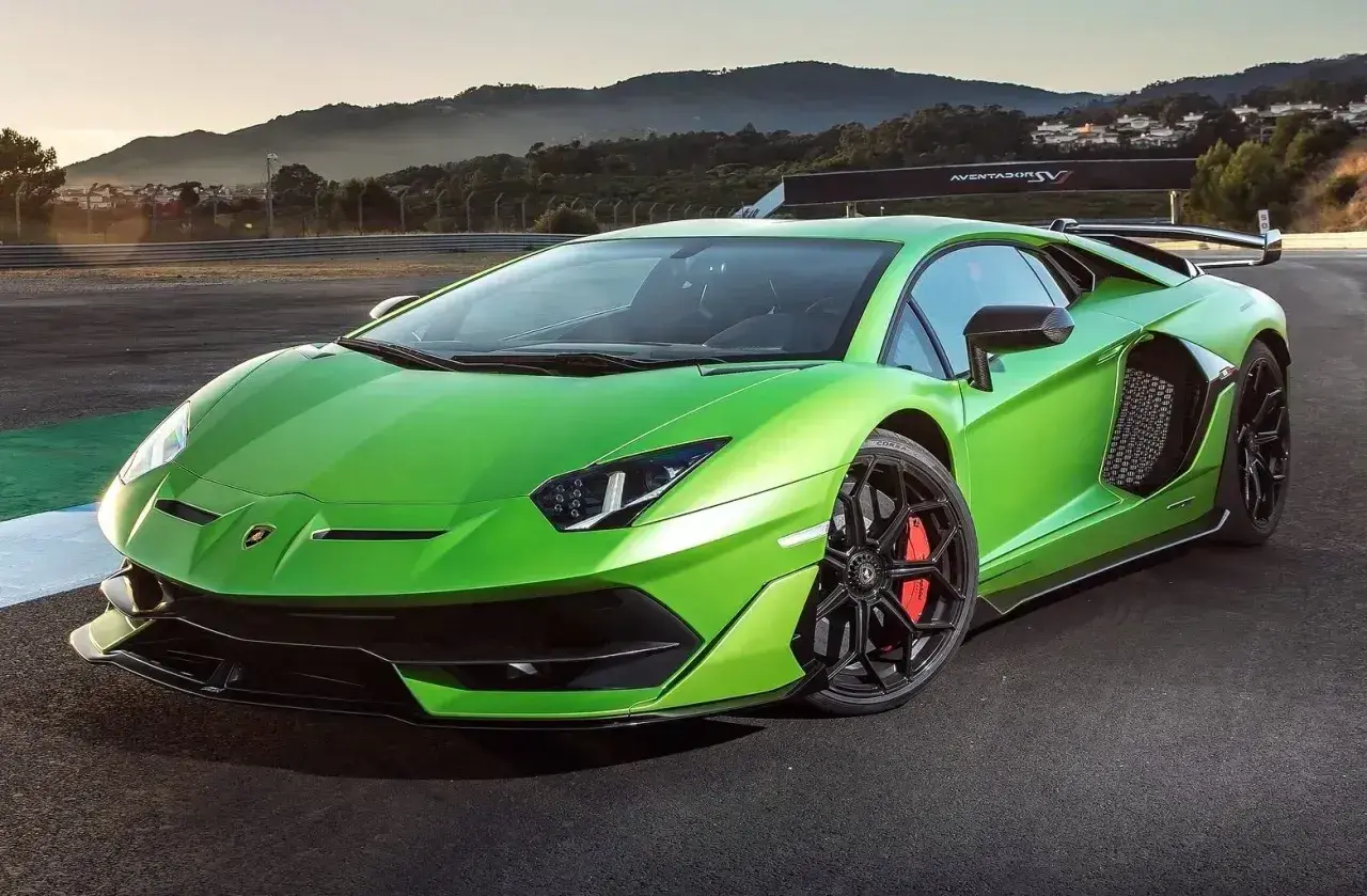 Jaskrawozielony Lamborghini Aventador SVJ na torze wyścigowym, z masywnym skrzydłem i czarnymi felgami.