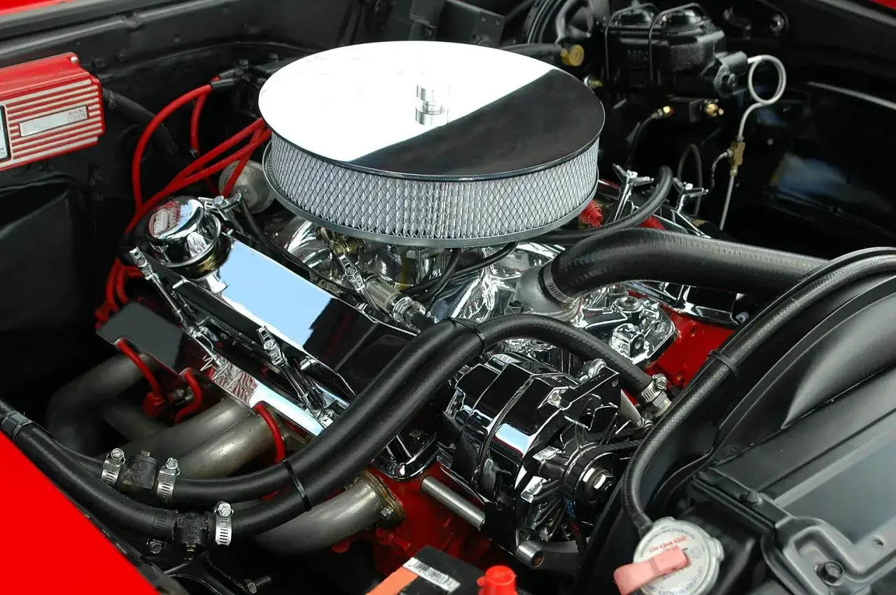 Błyszczący silnik V8 z chromowanymi elementami i filtrem powietrza. To prawdziwe konie mechaniczne, skrót do mocy i stylu.