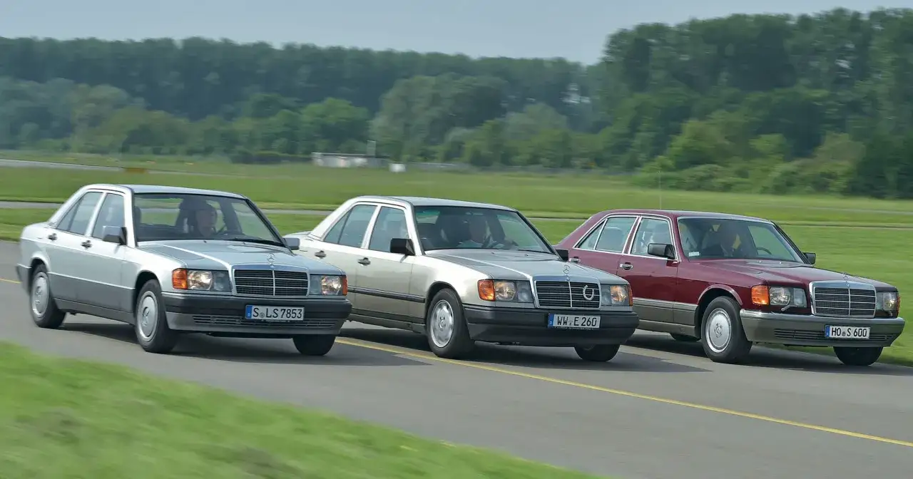 Trzy klasyczne Mercedesy, prawdziwe konie mechaniczne, jadą obok siebie po drodze.