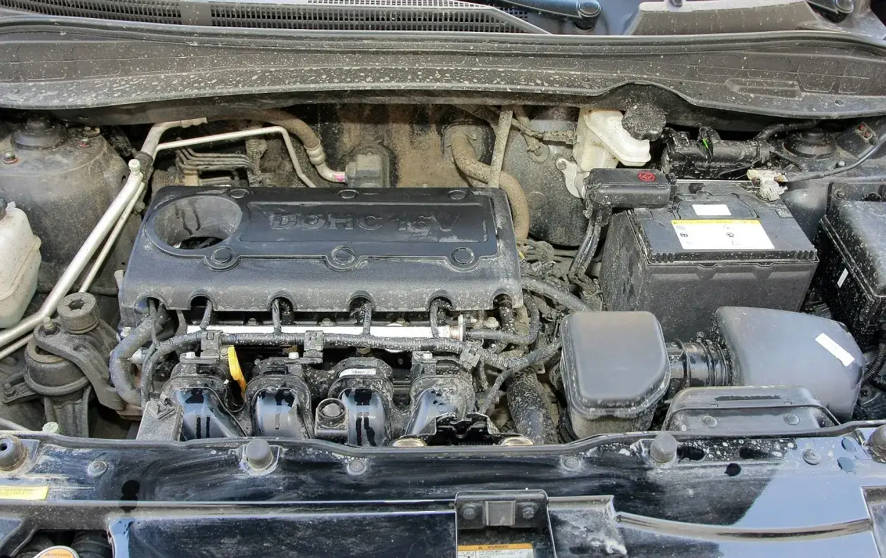 Silnik Hyundai ix35 2.0 benzyna, widoczny pod maską, z widocznymi przewodami i akumulatorem.